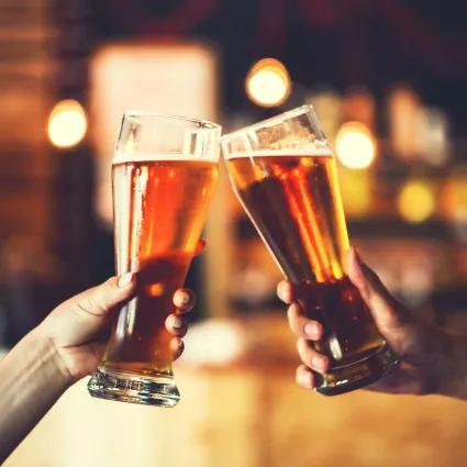 Two large beer glasses being cheersed