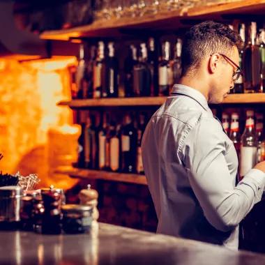 Man behind bar looking on a tablet