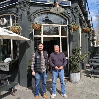 two men stood outside a pub