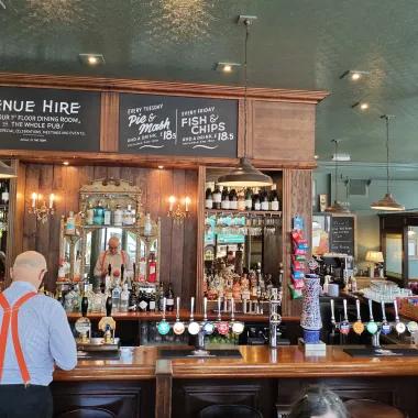 Many stood at a well stocked bar with his back to the camera