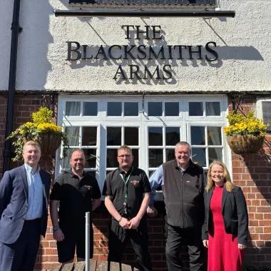 Group of people standing outside of pub